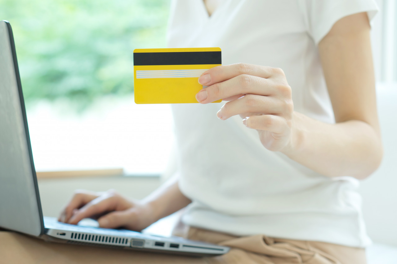 Woman holding credit card for online purchase